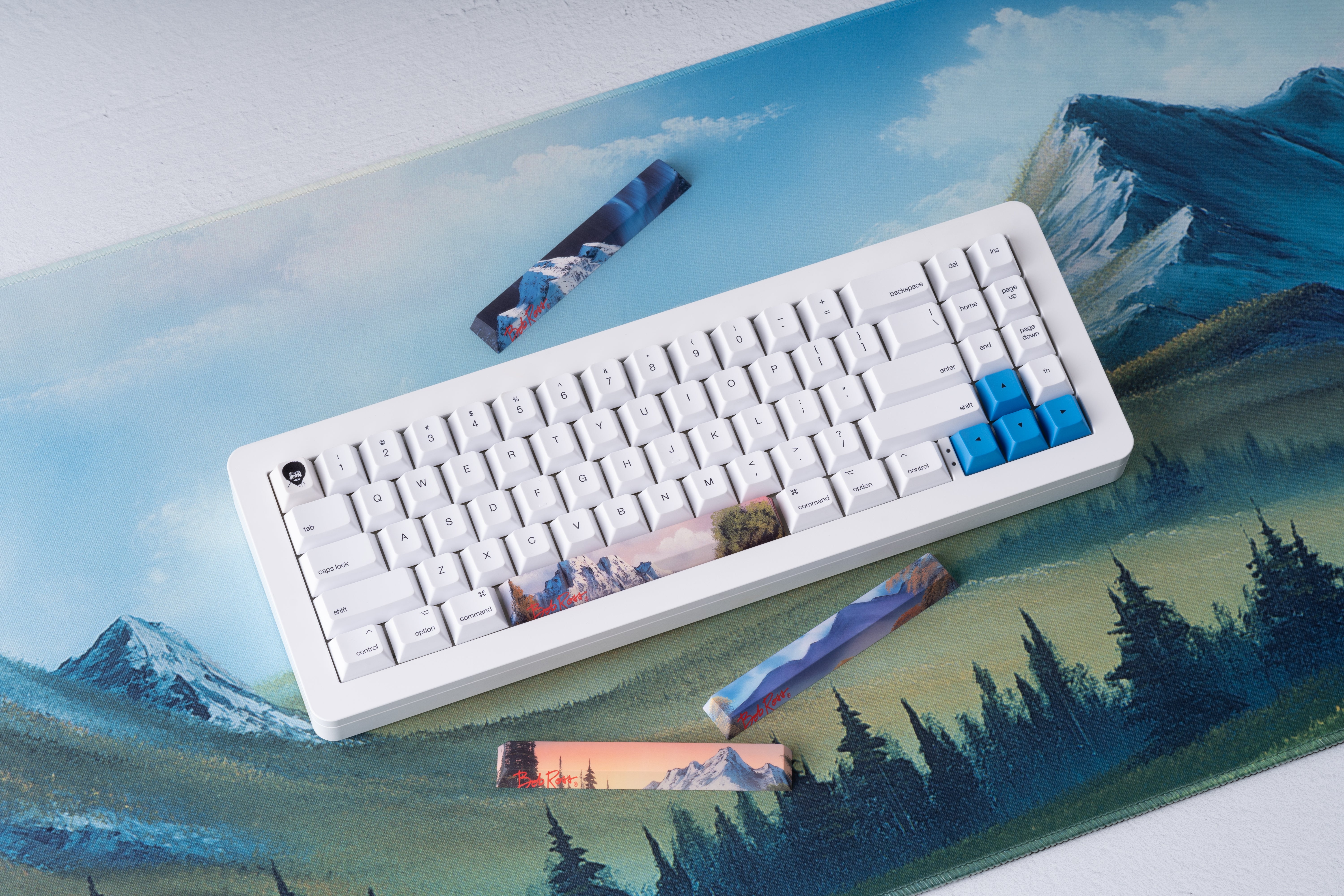 Apos x Bob Ross 키캡을 장착한 풀사이즈 키보드, 방향키가 파란색으로 포인트