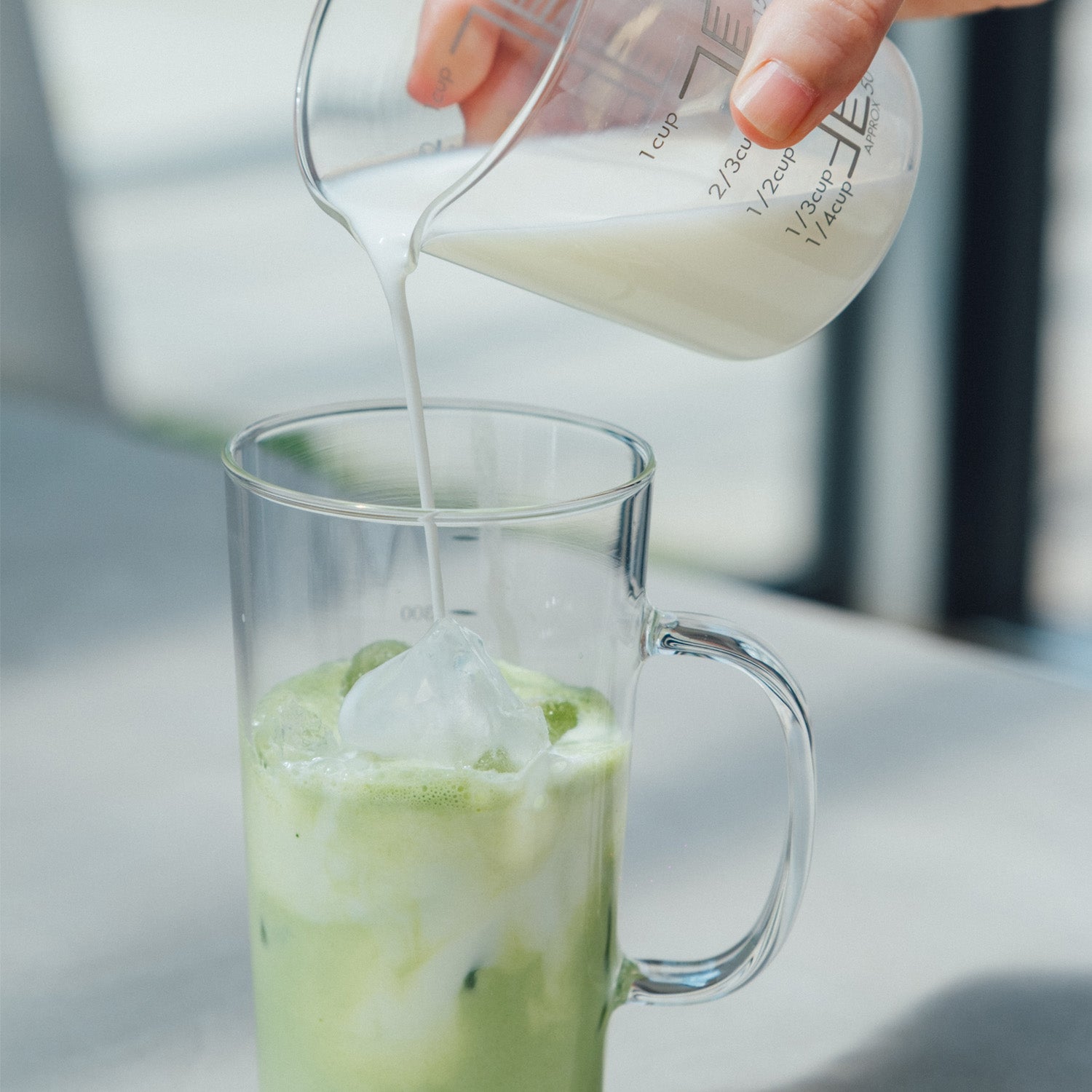 牛乳をフローサーで作ったカップに注ぐ様子