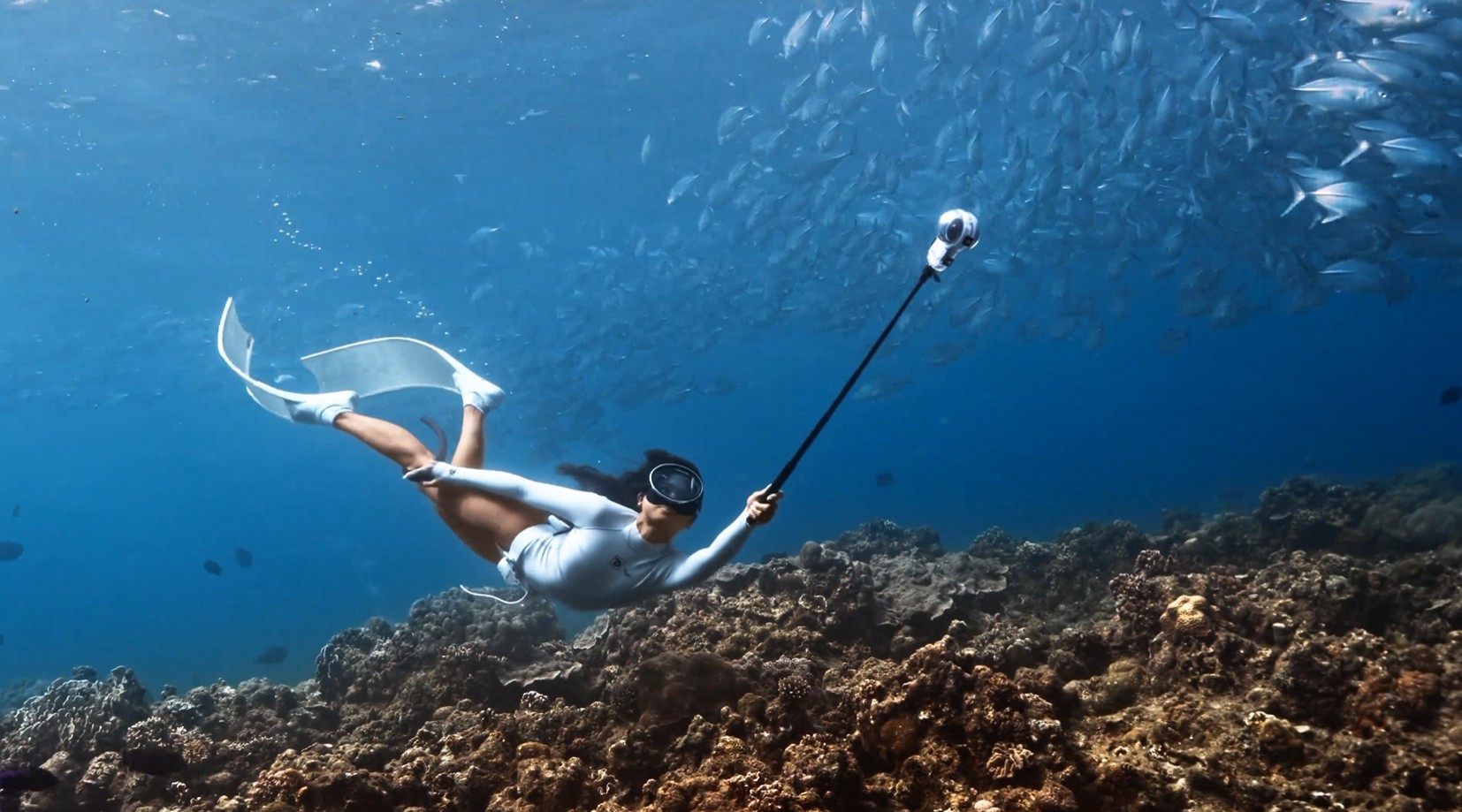 Insta360 X6 mounted on a selfie stick while diving