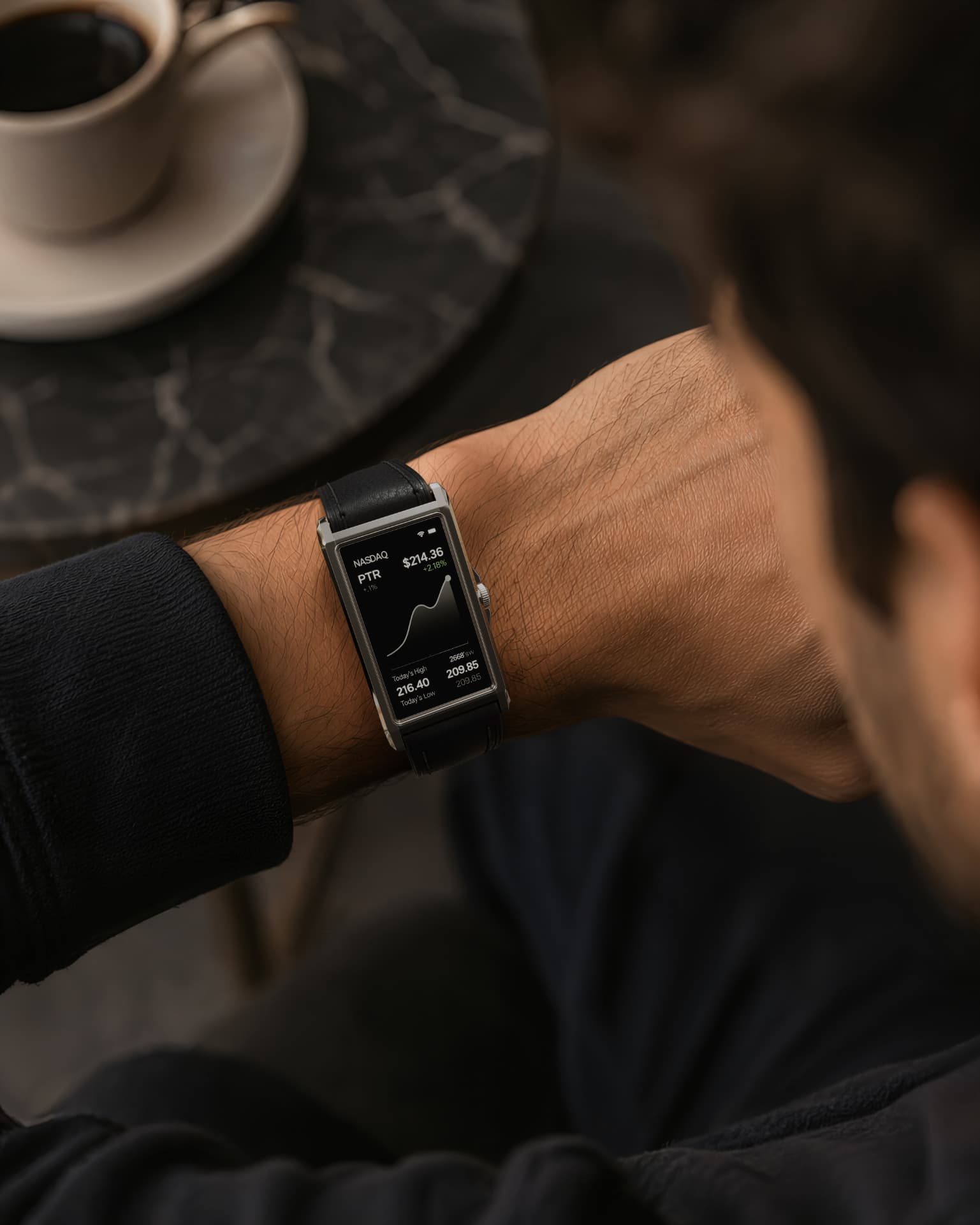 Screen showing stock prices while worn on the wrist at a café table