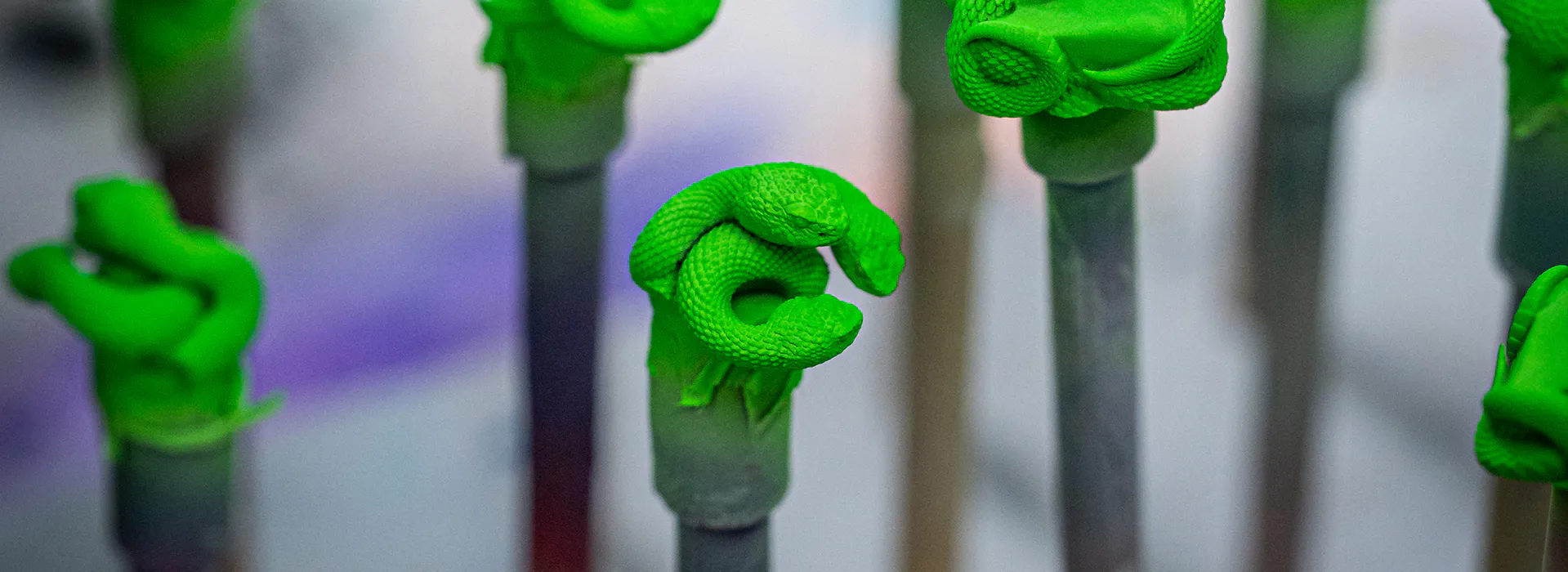 Several triple-headed snake keycaps lined up at the casting stage